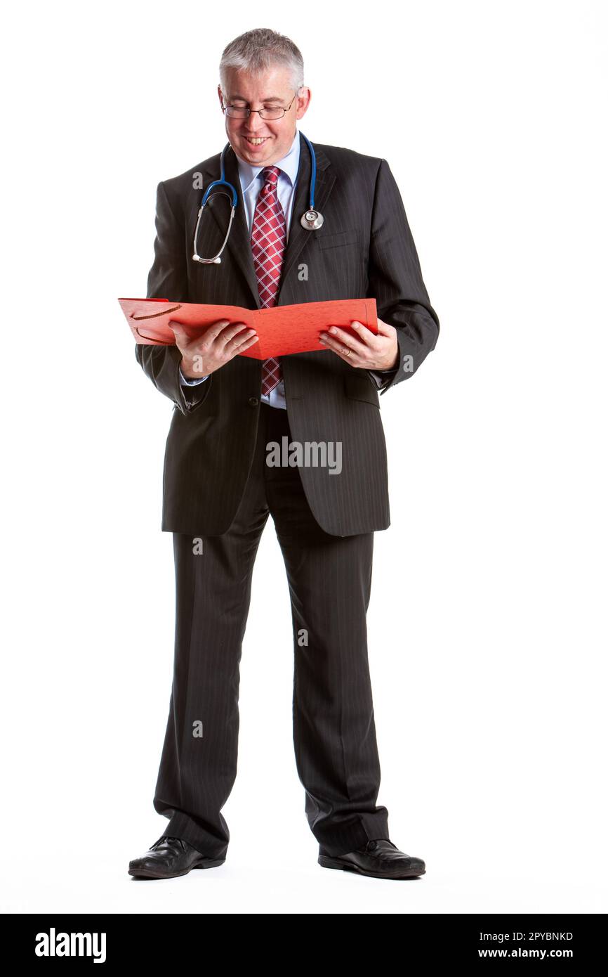 Professionnels de la santé : dossier médical. Portrait de studio en longueur sur blanc d'un médecin lisant ses notes. À partir d'une série d'images associées. Banque D'Images