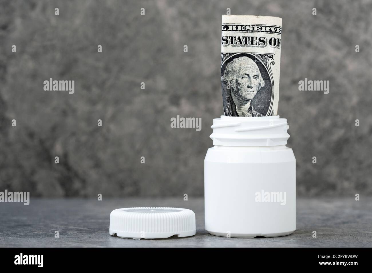 Billet de banque d'un dollar roulé dans la bouteille pharmaceutique Banque D'Images