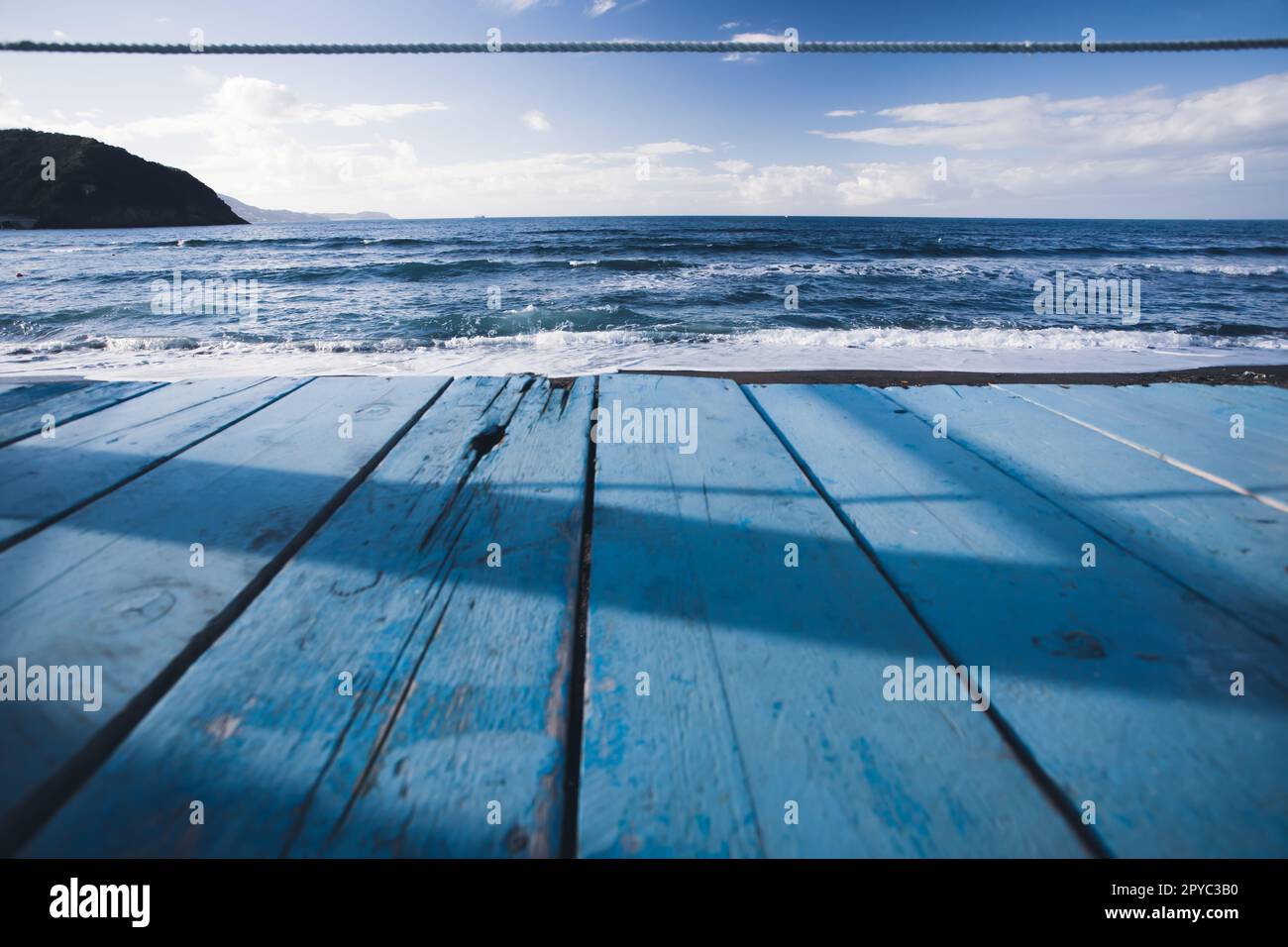 Perspective en bois sur le rivage de l'eau bleue et ciel bleu à la côte Banque D'Images