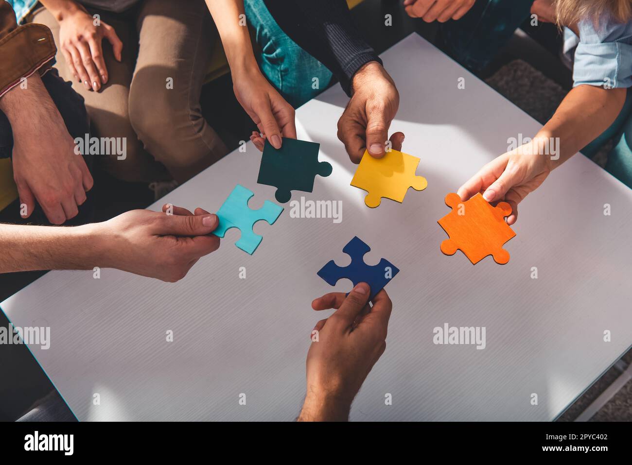 Le travail d'équipe des partenaires relie des pièces de puzzle comme intégration et démarrage Banque D'Images