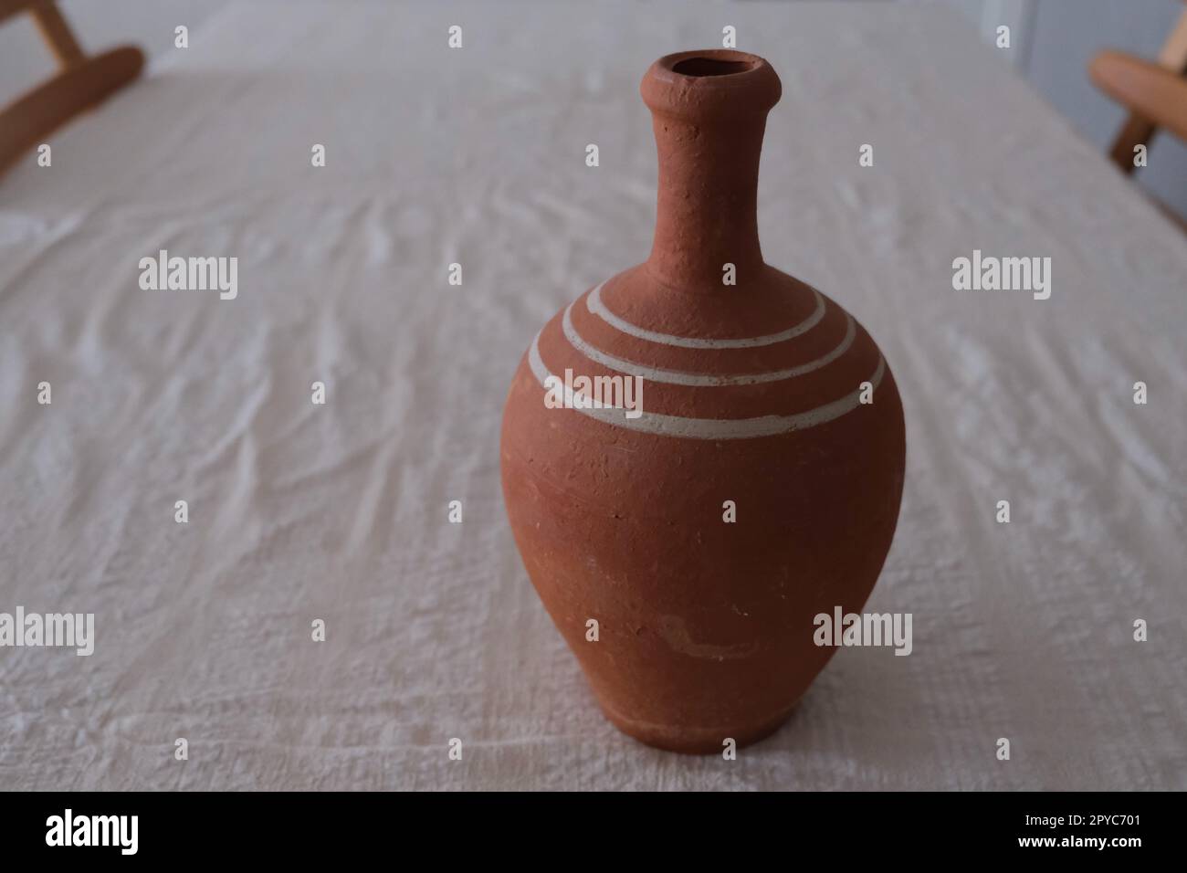 Gros plan sur une nappe blanche, pichet d'argile en céramique antique non peinte. Pichet en argile pour boire du vin ou de l'eau. Banque D'Images