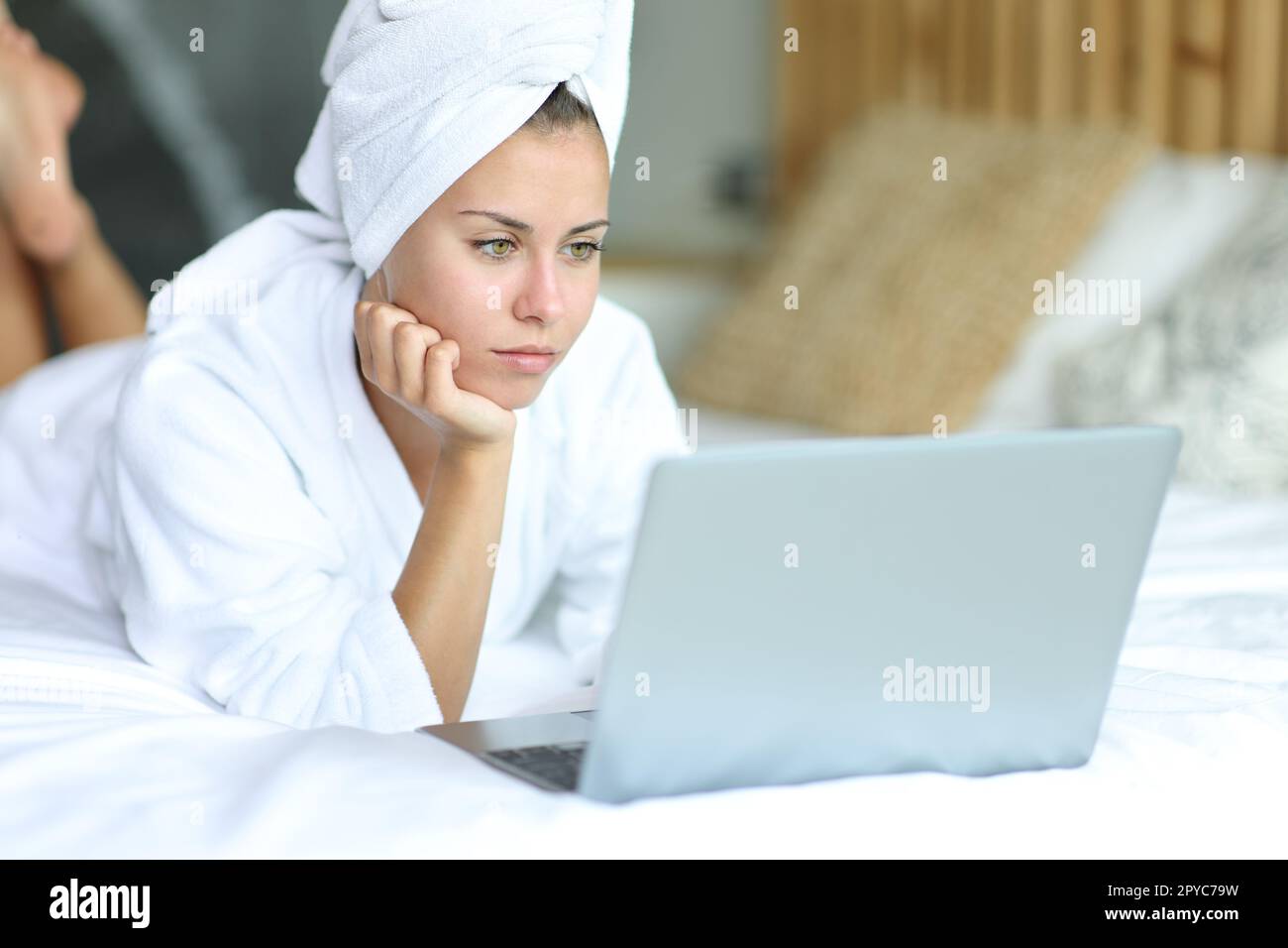 Femme dans le lit après la douche à l'aide d'un ordinateur portable Banque D'Images