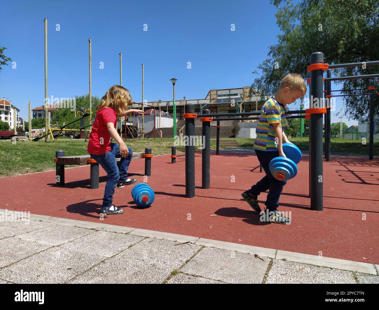 Sremska Mitrovica, Serbie. 6 juin 2020. Tongs, musculation et haltères, exercices de musculation. Deux adolescents font du sport sur des simulateurs, des enfants sur un terrain de sport Banque D'Images