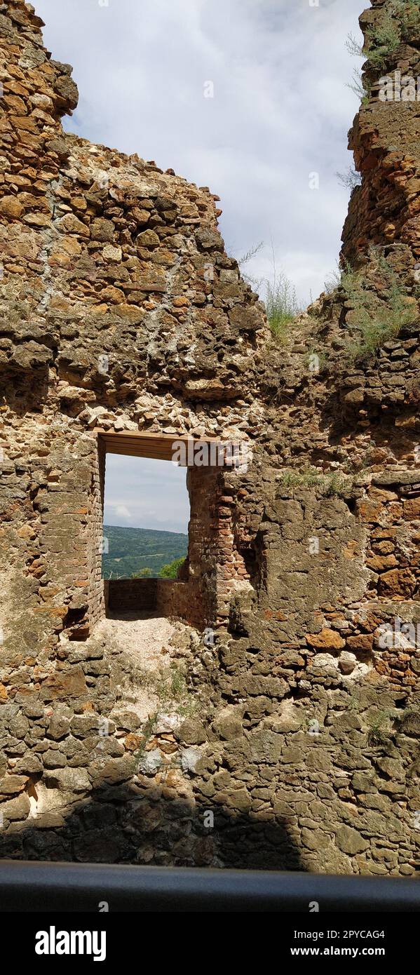 Ruines d'une ancienne forteresse à Vrdnik, Sremska Mitrovica, Voïvodine, Serbie. Anciens murs en pierre avec chaînes de montagnes en arrière-plan. Sites touristiques. Embrasure ou fenêtre pour l'observation et la défense Banque D'Images
