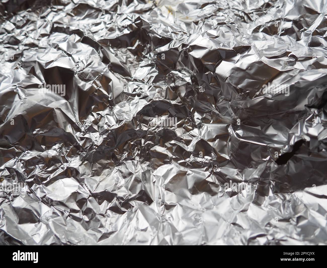 gros plan en aluminium. Feuille froissée d'aluminium et d'argent. Fond métallique abstrait. Feuille pour cuire des aliments. Contexte Banque D'Images