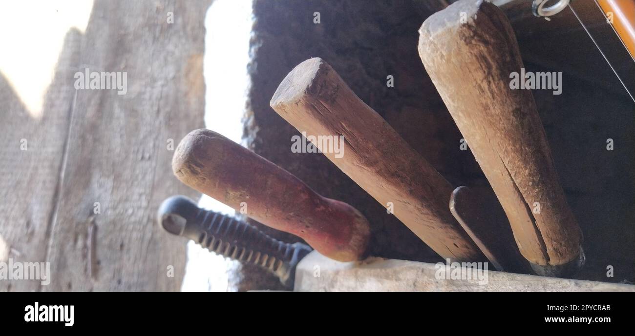 vieux outils agricoles aux murs de la maison. poignées d'outils de grange Banque D'Images