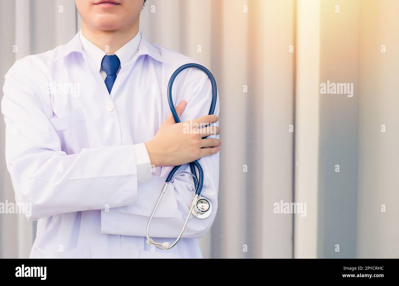 Portrait médecin homme souriant bras croisés tenir stéthoscope Banque D'Images