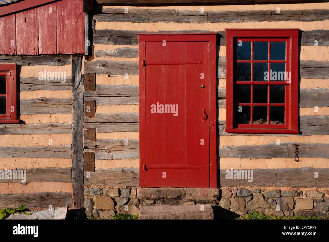 Gros plan extérieur de la cabine en rondins avec fenêtre et porte rouges Banque D'Images