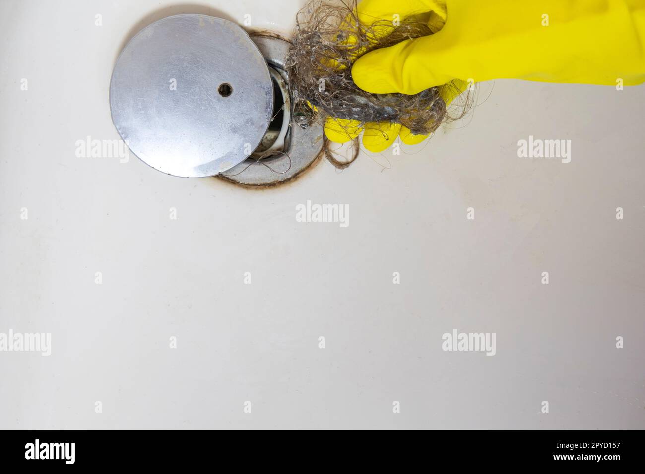 Le drain de la douche est bouché par les cheveux, la perte de poils dans une salle de bains après avoir lavé les cheveux dans la douche, nettoyant la salle de bains et enlevant la vue de dessus de cheveux Banque D'Images