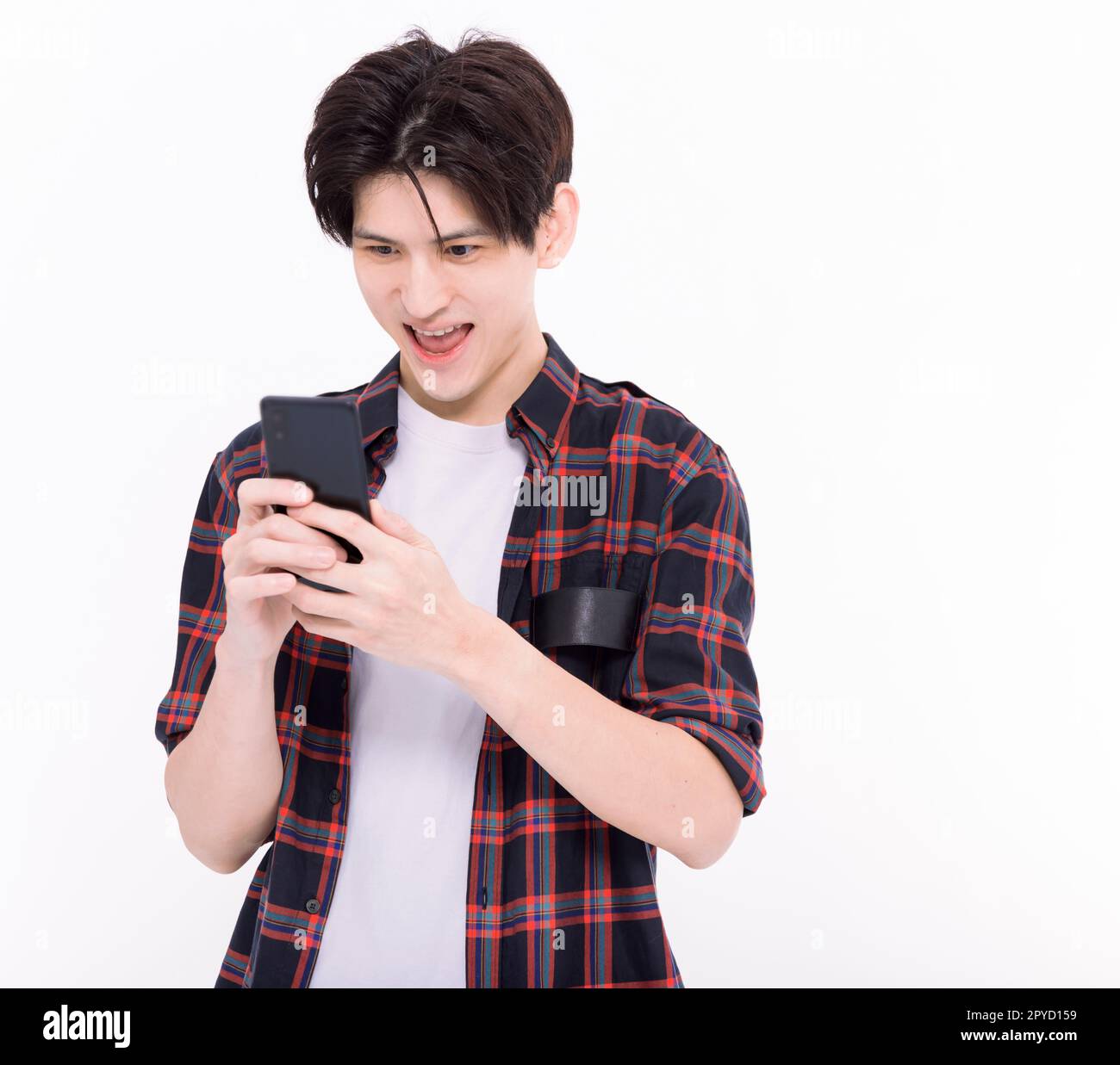 Un jeune étudiant asiatique rit et regarde le smartphone Banque D'Images