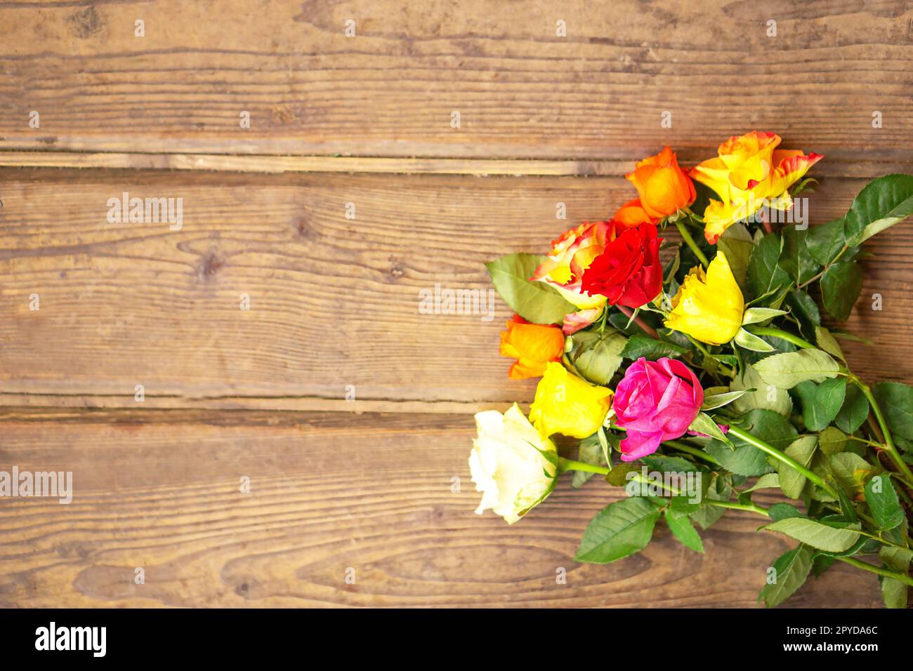 Bouquet de fleurs roses colorées sur le fond en bois brun vintage. Vue de dessus avec espace de copie. Carte de voeux pour la fête des mères ou des femmes. Photo de haute qualité. Banque D'Images