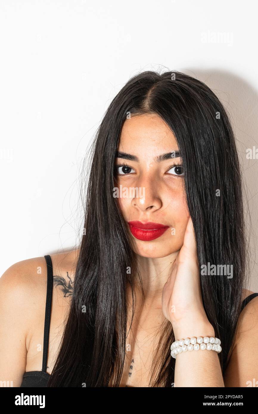 portrait rapproché d'une belle jeune femme latina avec une main sur sa joue en regardant droit devant. Banque D'Images