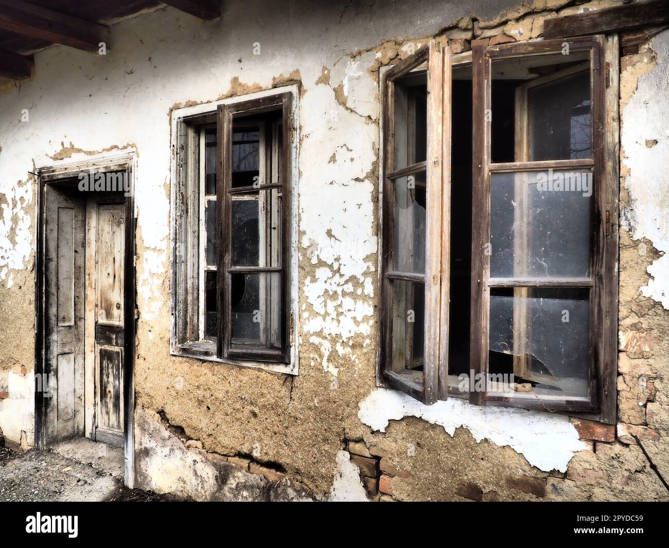 Maison ancienne avec fenêtres et une porte. Maison rurale en train de s'effondrer. Le concept d'urbanisation et d'oubli de la mère patrie. Maison abandonnée. Verre brisé dans les fenêtres et plâtre tombant. Serbie. Balkans Banque D'Images