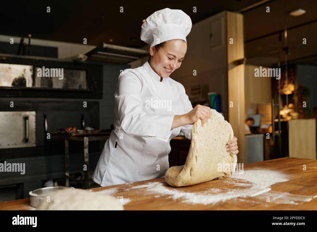 Pétrissage ou formation de pâte pour boulanger une femme en travaillant au bakehouse Banque D'Images