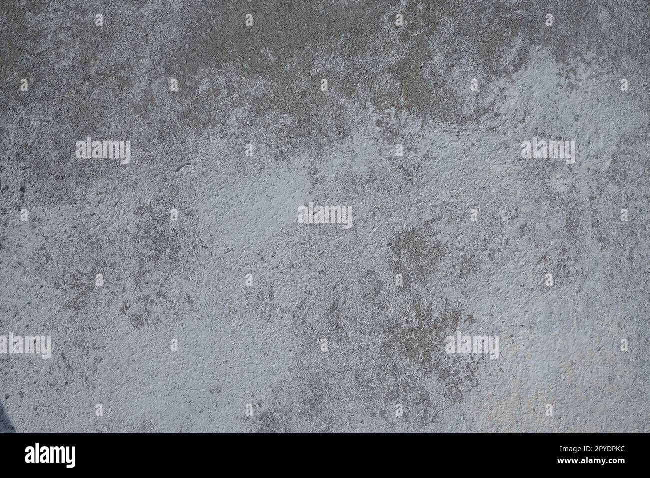 Texture plaquée. Surface blanchie à la chaux. Arrière-plan abstrait. Texture de structure rétro. Fissures et bosses sur le mur en béton. Coloration inégale avec peinture à base d'eau. Vieux plâtre en lambeaux Banque D'Images
