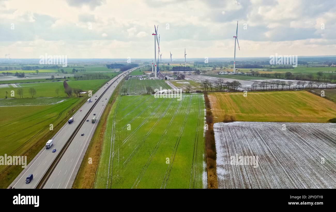 Vue de dessus sur l'autoroute allemande A7 avec quelques moulins à vent pour l'électricité renouvelable en construction. Banque D'Images