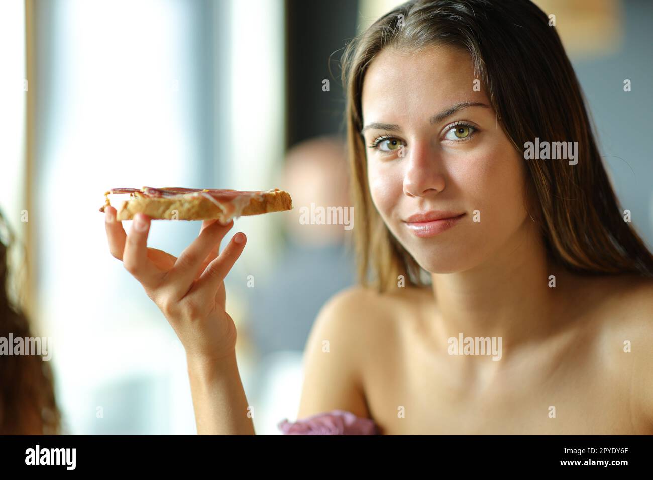 Femme regarde la caméra tenant du pain avec de la confiture Banque D'Images