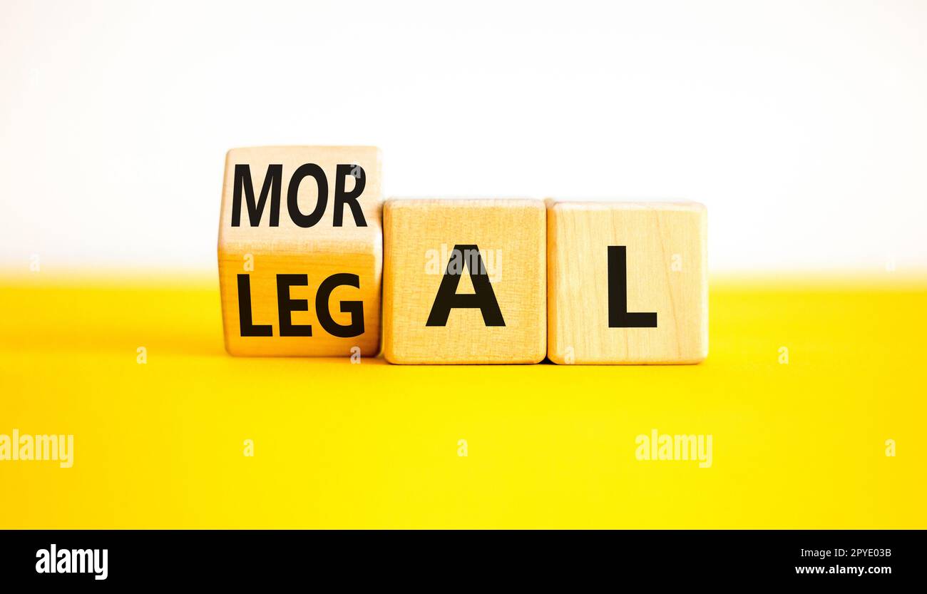 Symbole juridique ou moral. L'homme d'affaires tourne des cubes en bois et change le mot Légal à moral sur un magnifique fond blanc de table jaune. Business et L Banque D'Images