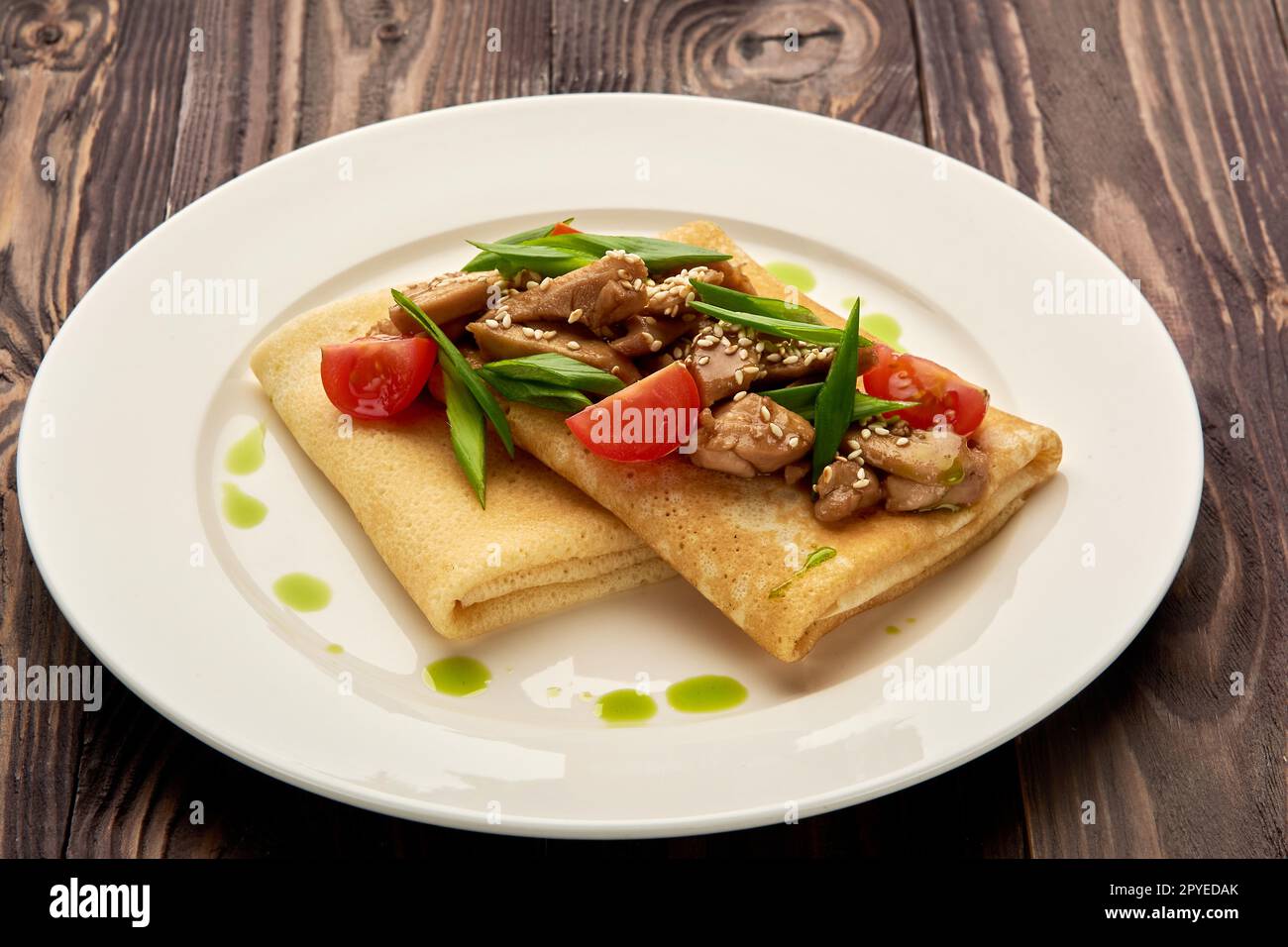 crêpes juteuses avec viande et tomates sur une assiette blanche Banque D'Images