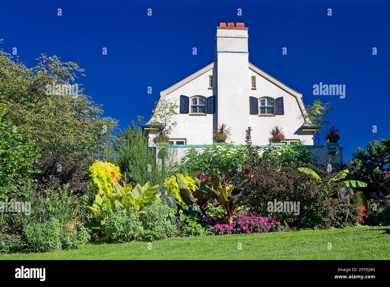 Chanticleer House, vue latérale, jardin ; 1913, antique, blanc, volets noirs, cheminée, herbe verte, arbustes, Trees, Pennsylvanie; Wayne; PA; été Banque D'Images