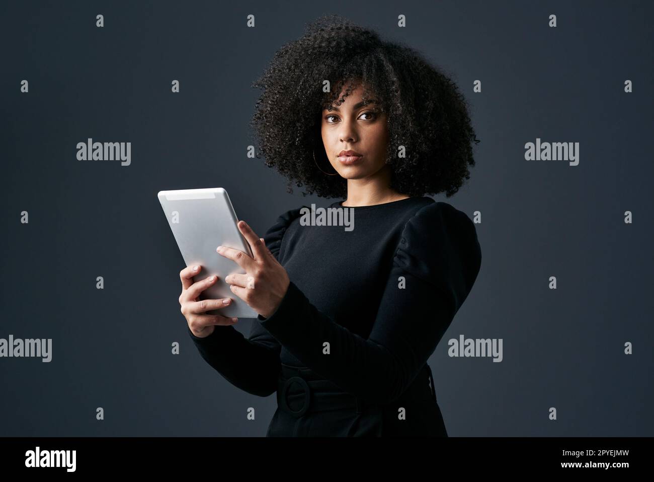 Il faut du temps pour y répondre. une jeune femme d'affaires utilisant une tablette numérique sur un fond de studio. Banque D'Images