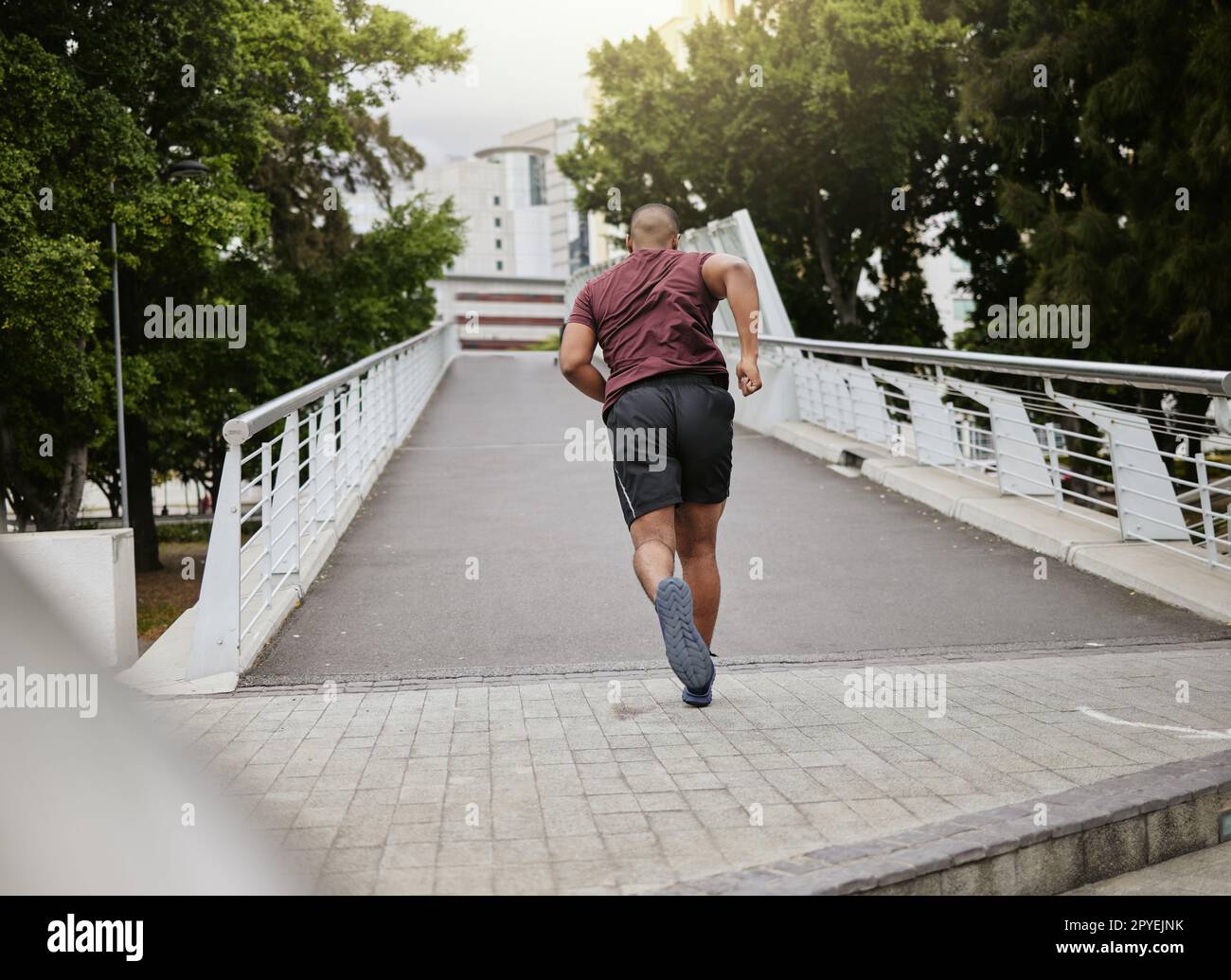 Fitness, exercice ou homme noir courant sur le pont en ville, rue ou route pour le bien-être, cardio entraînement ou entraînement. Sport, vue arrière ou coureur à New York pour objectif de santé, marathon ou course Banque D'Images