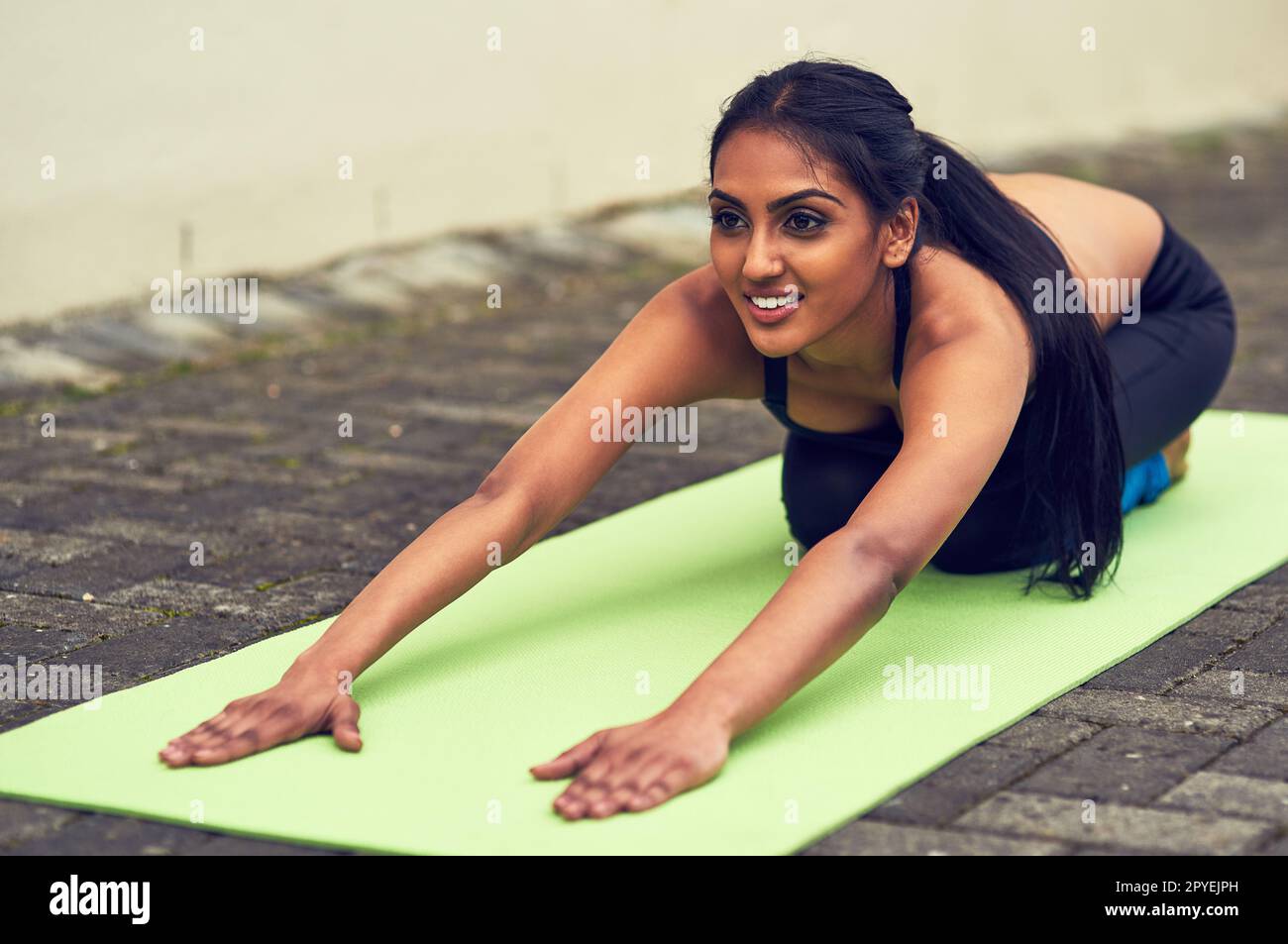 Plier et étirer peut faire beaucoup pour votre corps. une belle jeune femme pratiquant le yoga à l'extérieur. Banque D'Images