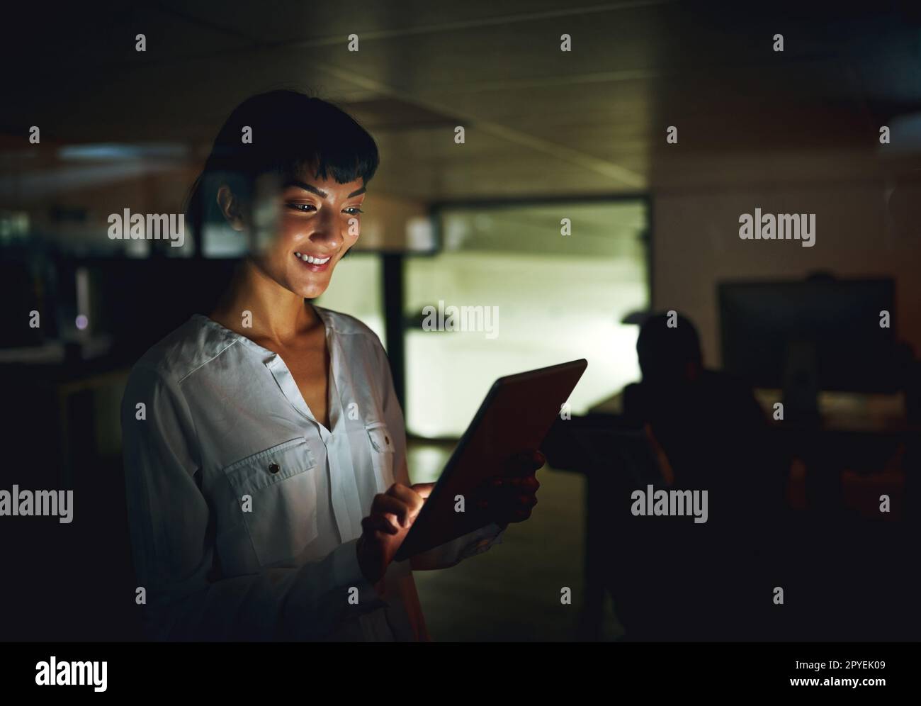 Une technologie intelligente lui fait passer la nuit. une jeune femme d'affaires utilisant une tablette numérique pendant une nuit de travail. Banque D'Images