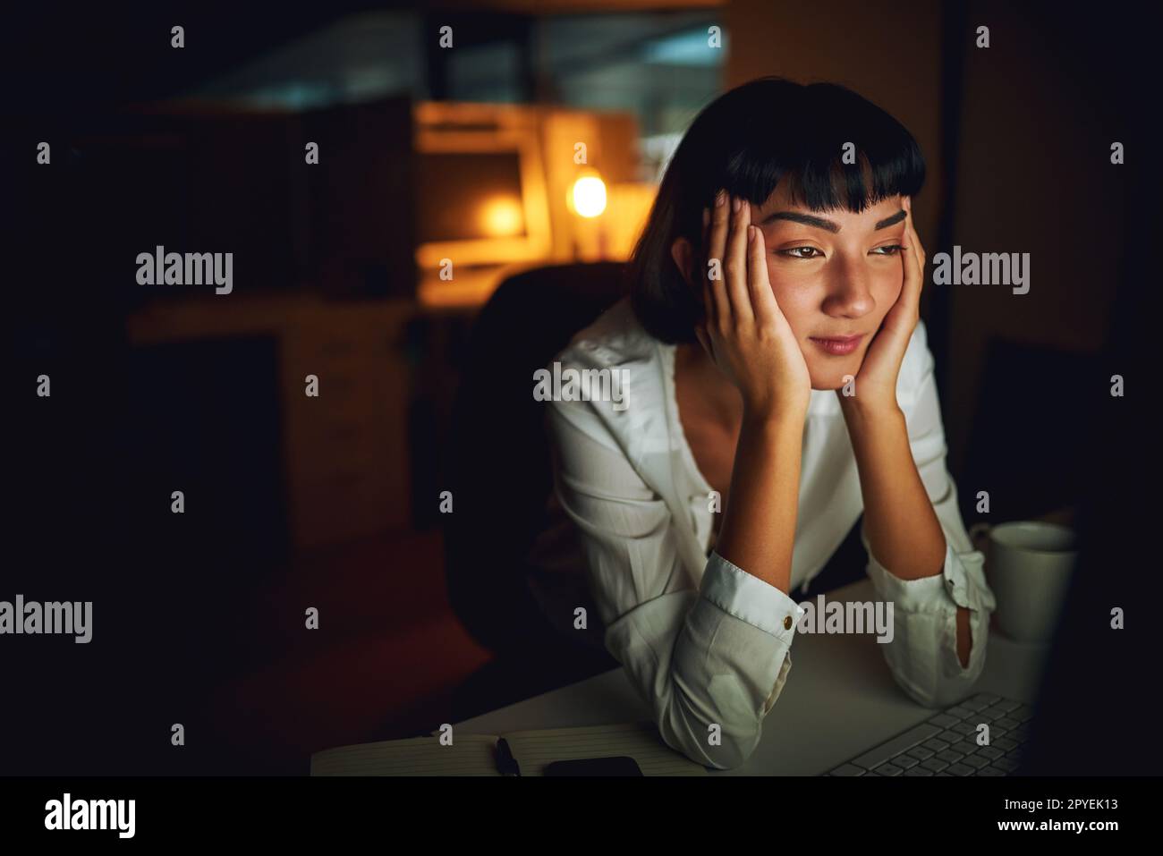 Doit rester éveillé... une jeune femme d'affaires se sentant fatiguée pendant une nuit de travail. Banque D'Images