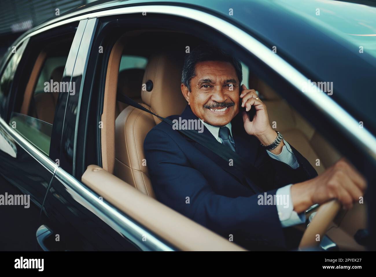 Succès - la seule façon est d'aller de l'avant. un homme d'affaires mature utilisant son téléphone lorsqu'il voyage dans une voiture. Banque D'Images