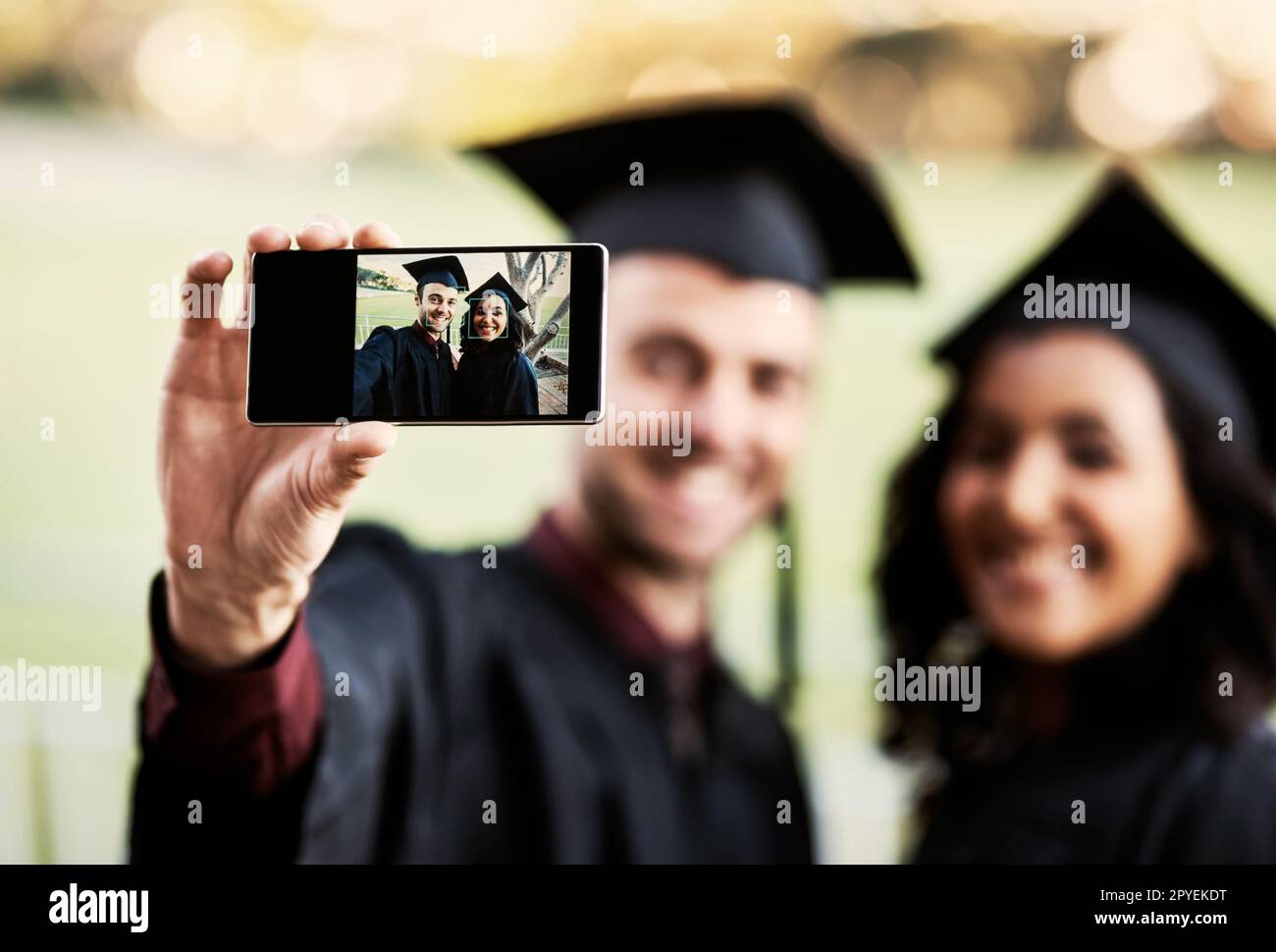 Regardez qui vient d'obtenir un diplôme. deux étudiants prenant un selfie ensemble le jour de la remise des diplômes. Banque D'Images