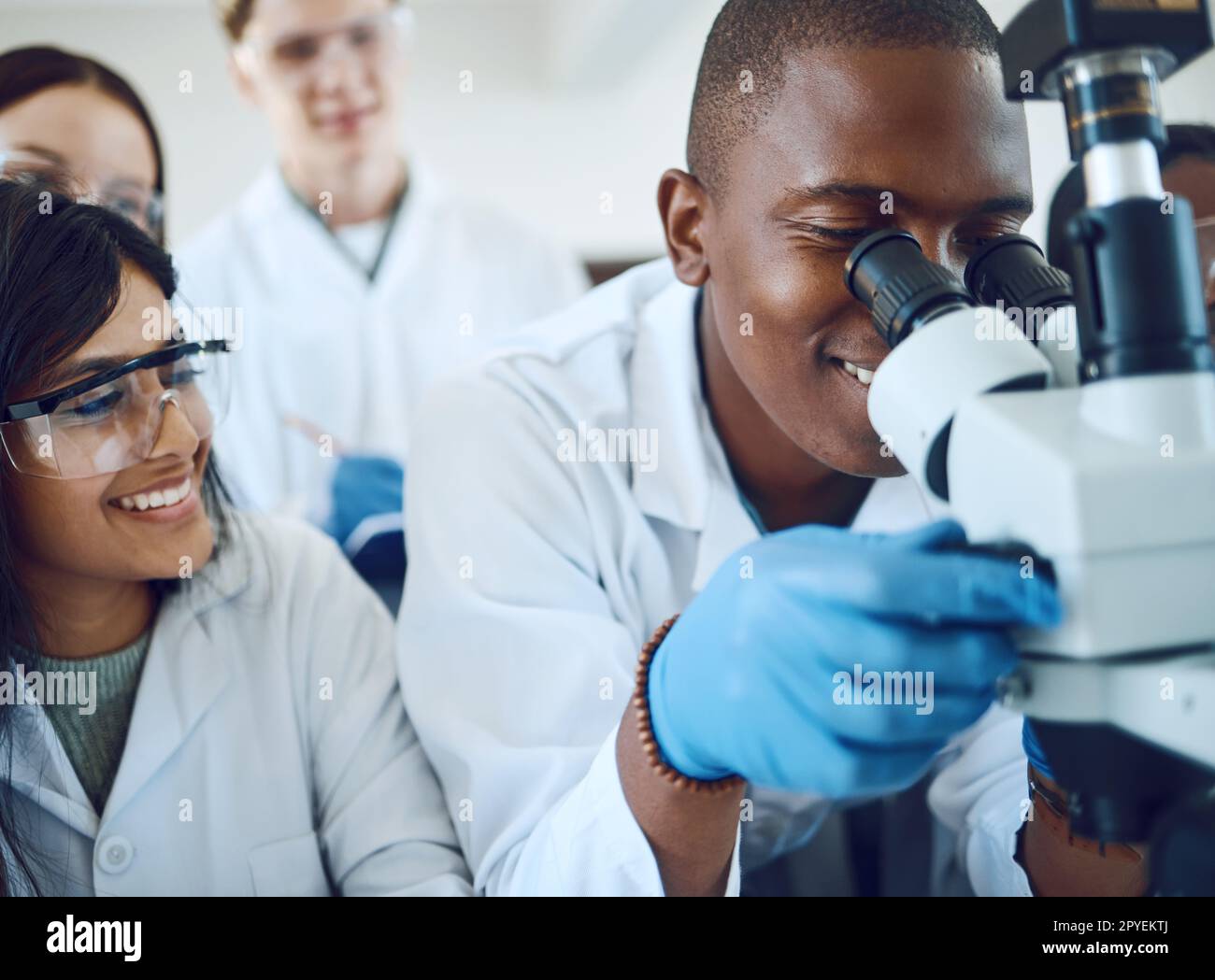 Microscope, science et équipe scientifique avec test d'étude pour la recherche, l'innovation médicale et la biotechnologie dans les soins de santé. Étudiants en pharmacie dans un laboratoire travaillant sur des bactéries ou des résultats d'adn Banque D'Images