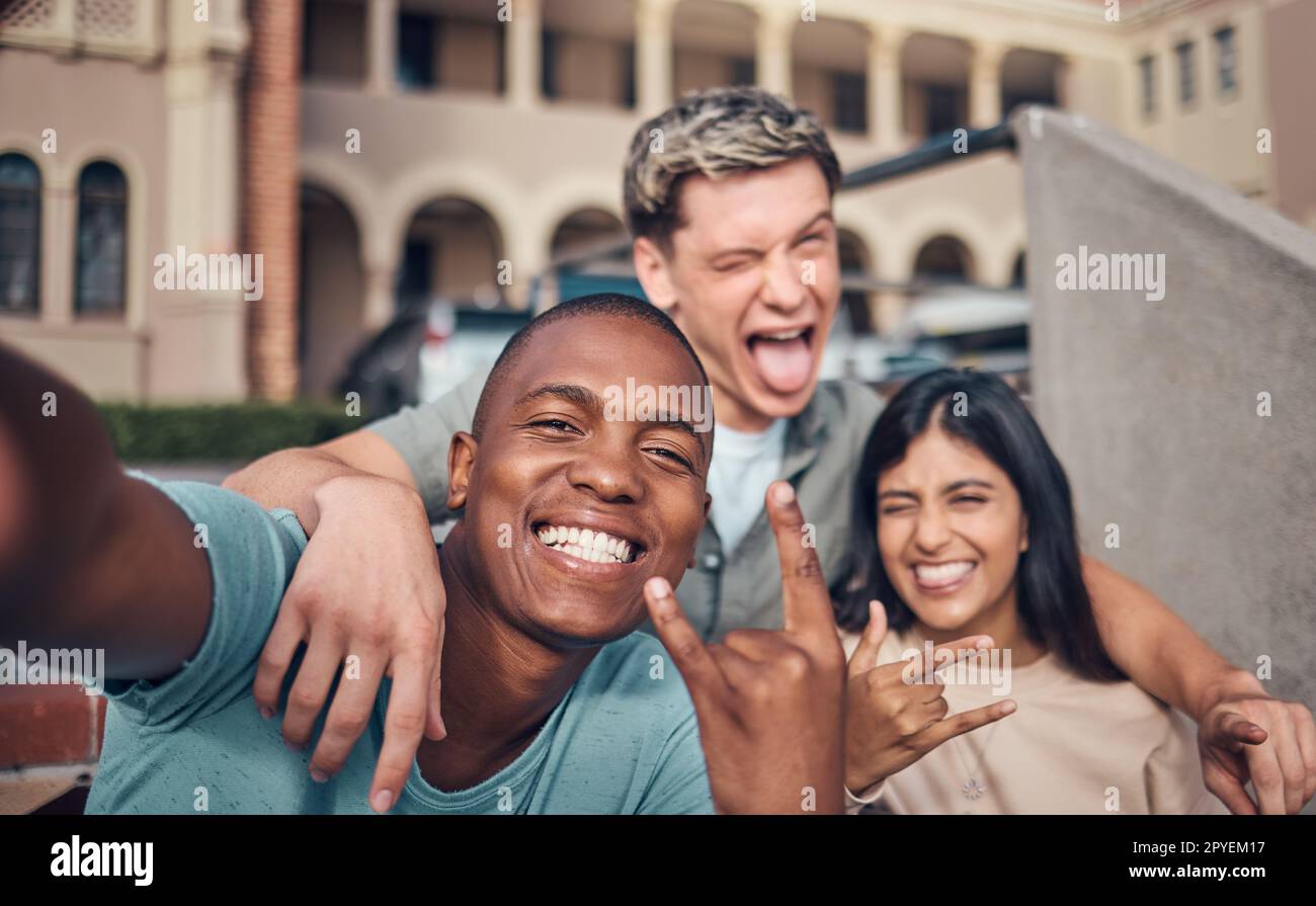 Amis selfie, sourire et portrait sur le campus universitaire avec diversité, visage heureux et drôle, geste de la main et signe de roche. Heureux, portrait et amitié interraciale de collège, étudiants et photographie Banque D'Images