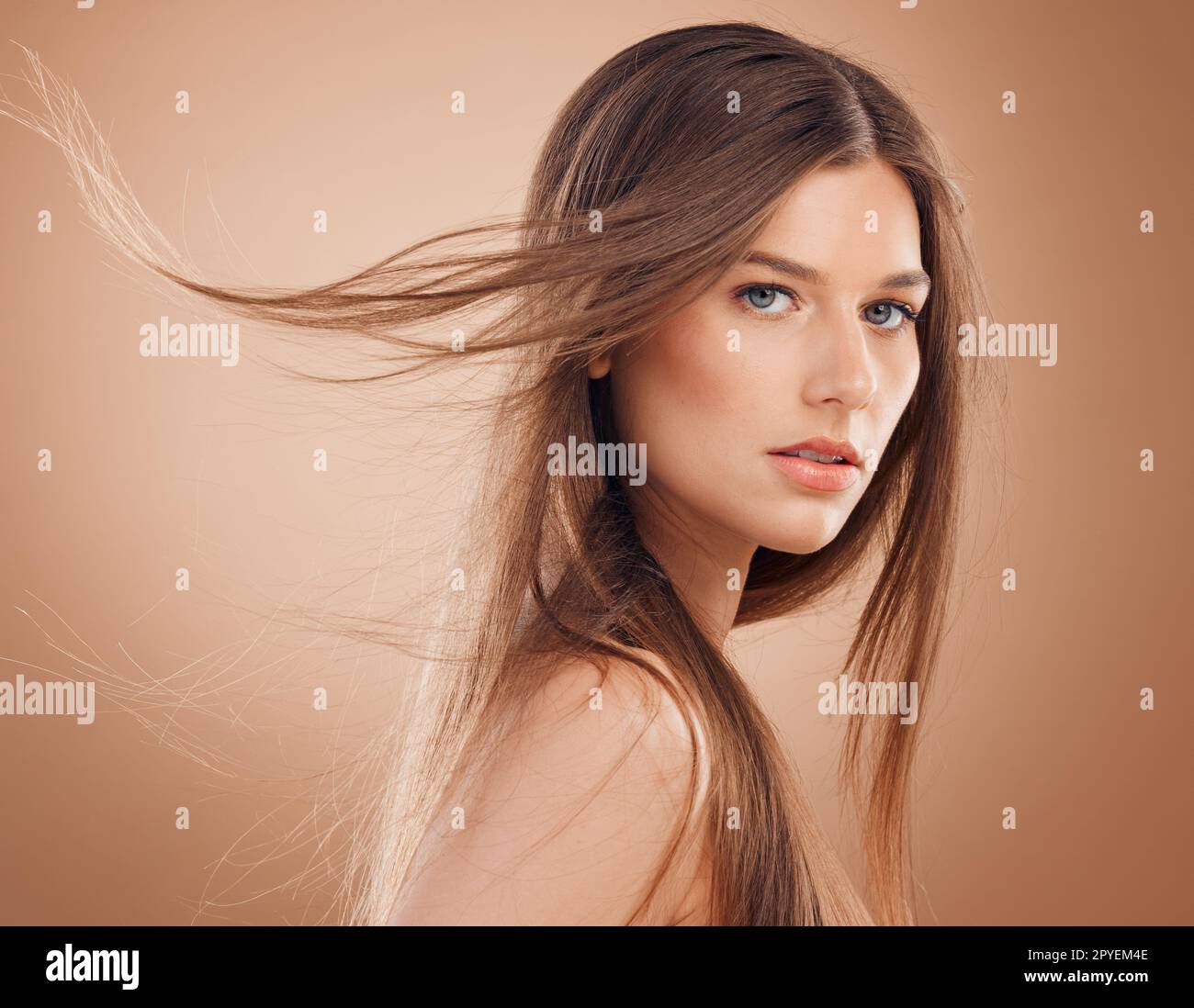 Femme, visage brillant ou cheveux venteux sur fond de studio dans le traitement de kératine, la santé dermatologique, les soins ou le bien-être de collagène. Portrait, modèle de beauté brunette ou cosmétiques de maquillage du visage pour les soins de la peau du Canada Banque D'Images