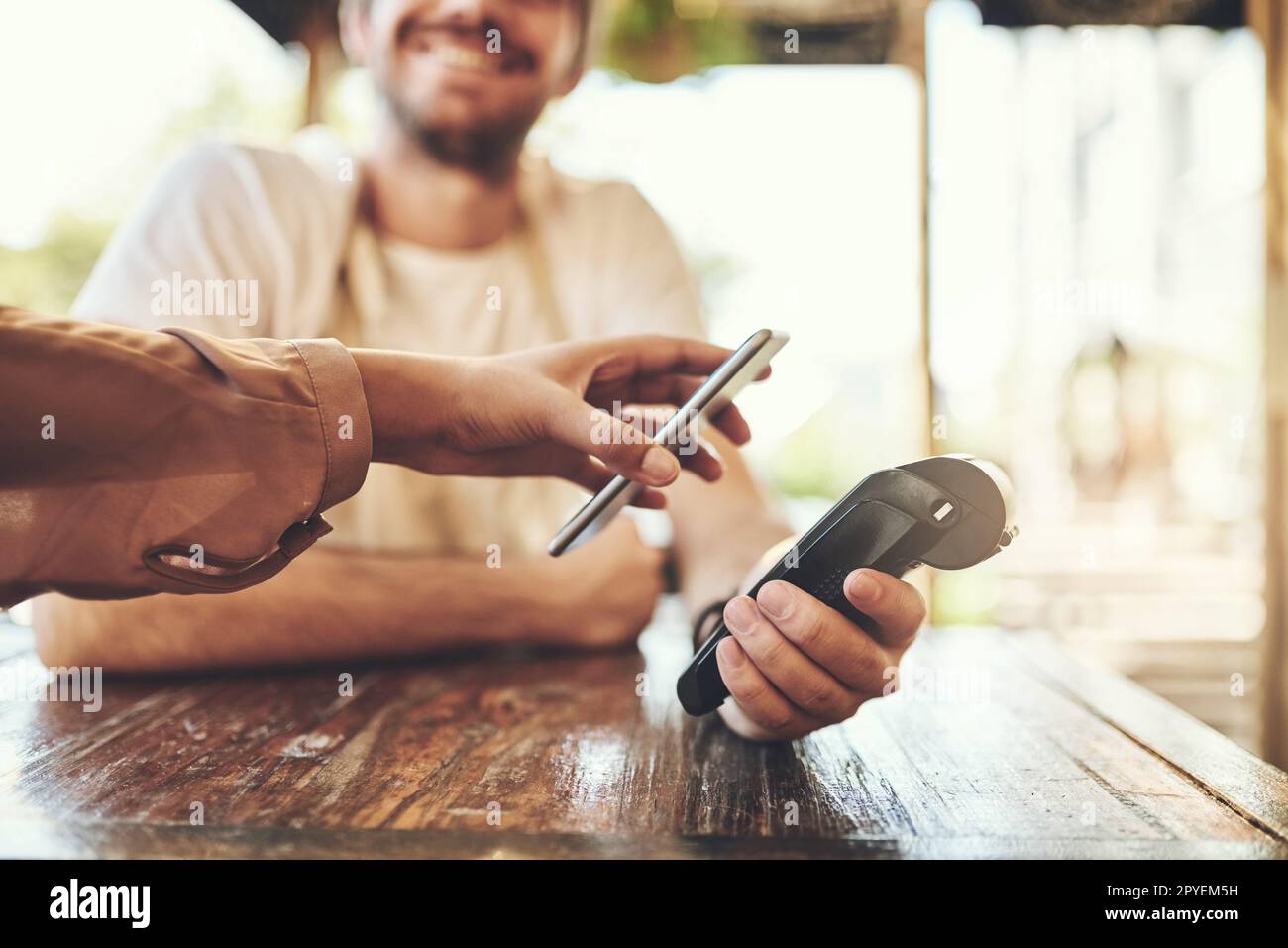 Pas besoin de portefeuilles aujourd'hui. un client effectuant un paiement sans fil dans un café. Banque D'Images