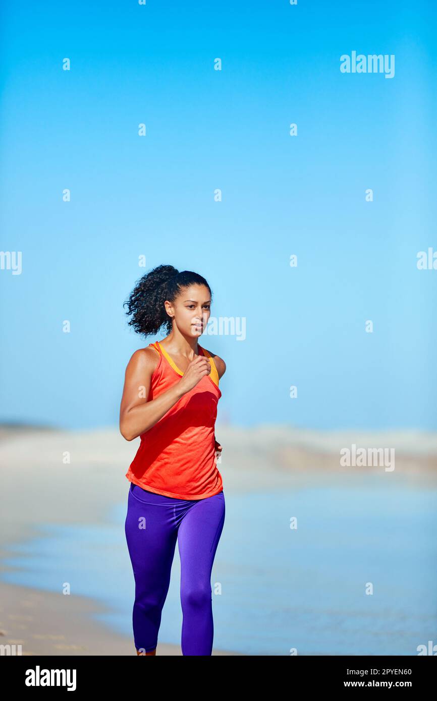 Courez aussi dur que possible. une jeune femme sportive à la plage pour sa course du matin. Banque D'Images