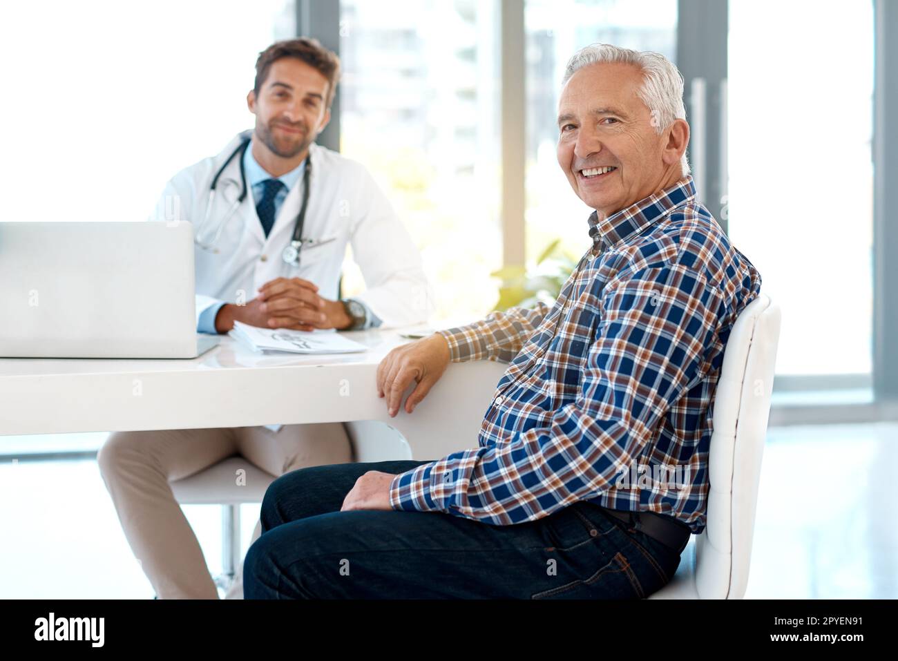 HES le seul médecin en qui j'ai confiance. Portrait court d'un beau médecin de sexe masculin consultant un patient à son bureau. Banque D'Images