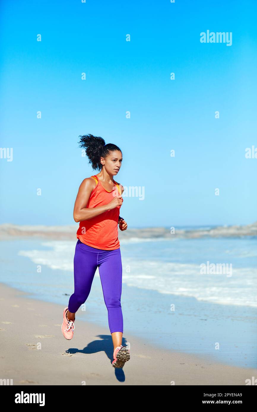 Faire ce que vous aimez, c'est la liberté. une jeune femme sportive à la plage pour sa course du matin. Banque D'Images