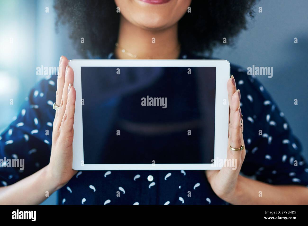 Tout le monde le téléchargeant. une jeune femme tenant une tablette numérique avec un écran vierge. Banque D'Images