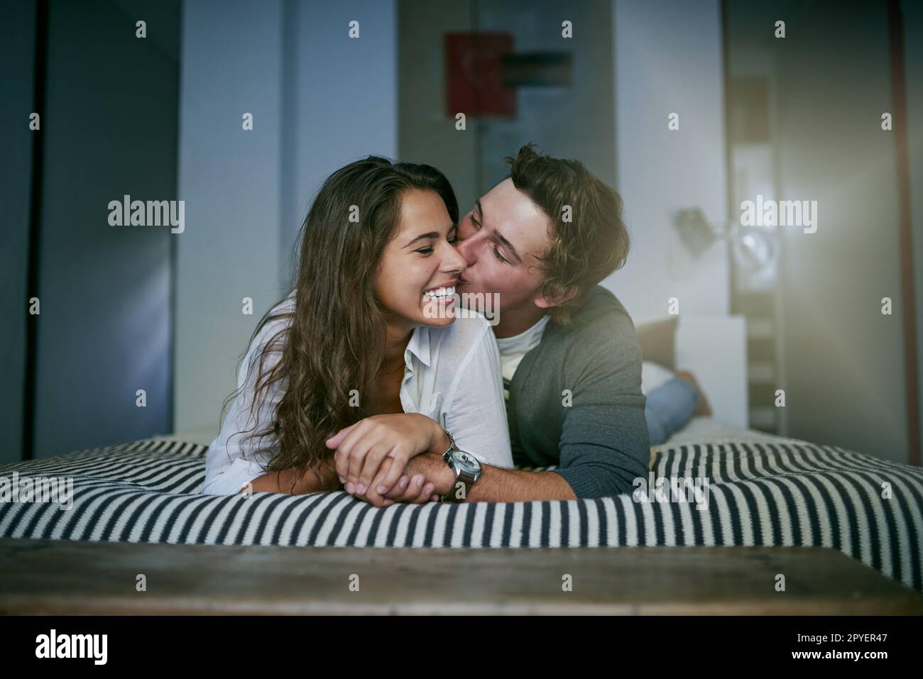 Rester amoureux est facile pour nous. un jeune couple affectueux couché sur le lit. Banque D'Images