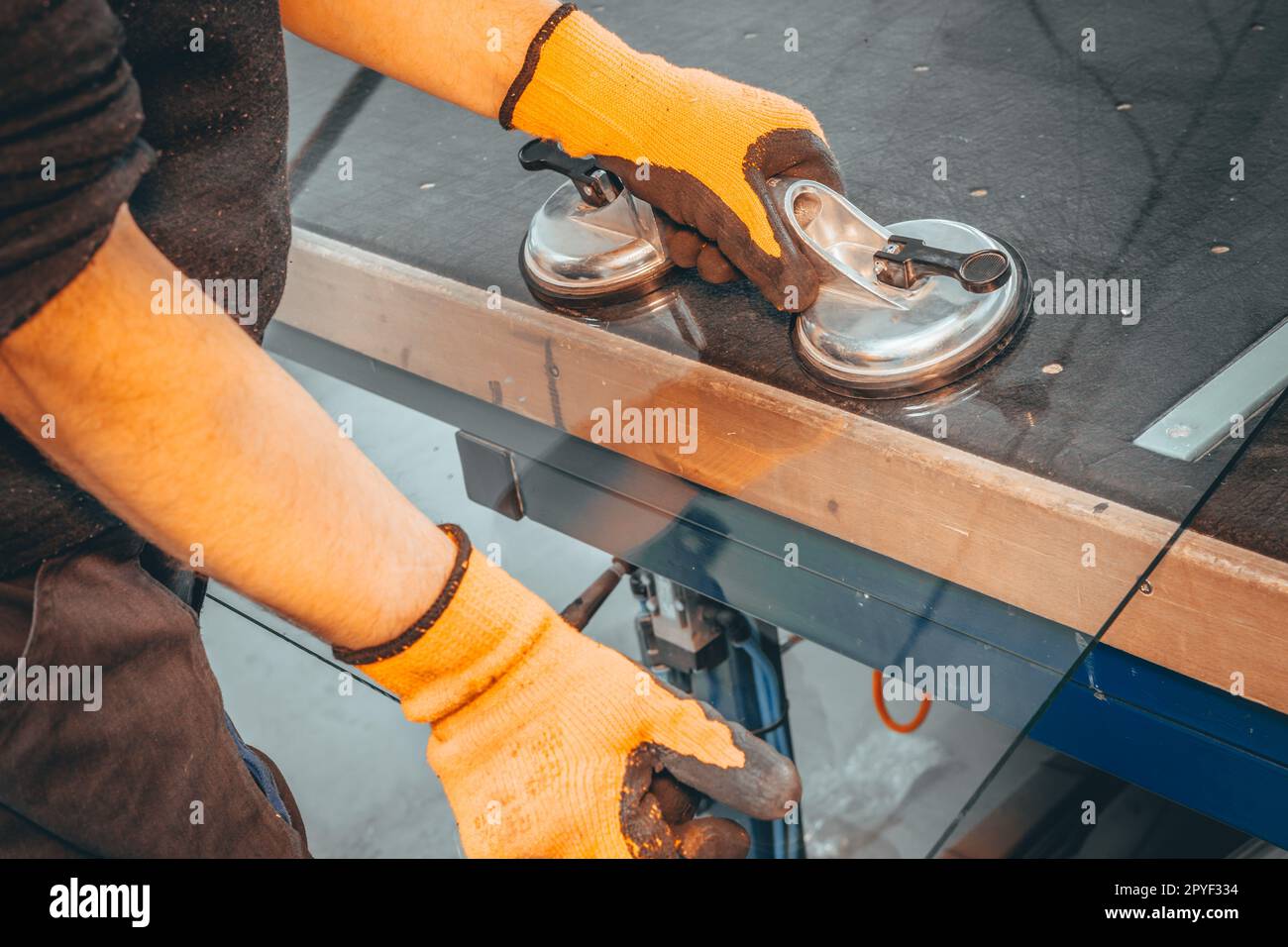 Le vitrier place un grand panneau de verre sur la table à vitrages à l'aide d'une ventouse spécialisée, concept industriel-industriel Banque D'Images