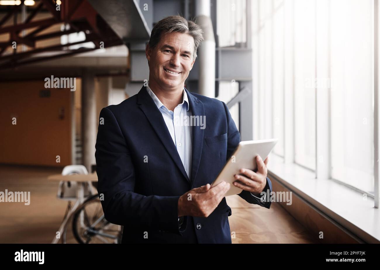 Étendre votre entreprise au marché mondial est un véritable investissement. Portrait d'un homme d'affaires mature utilisant une tablette numérique dans un bureau. Banque D'Images