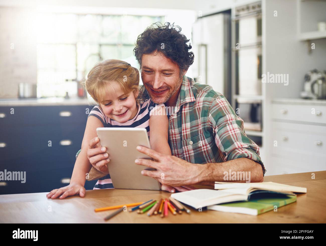 Devenir un étudiant de haut niveau avec l'aide de Dad. un père aidant sa fille à faire ses devoirs sur une tablette numérique. Banque D'Images