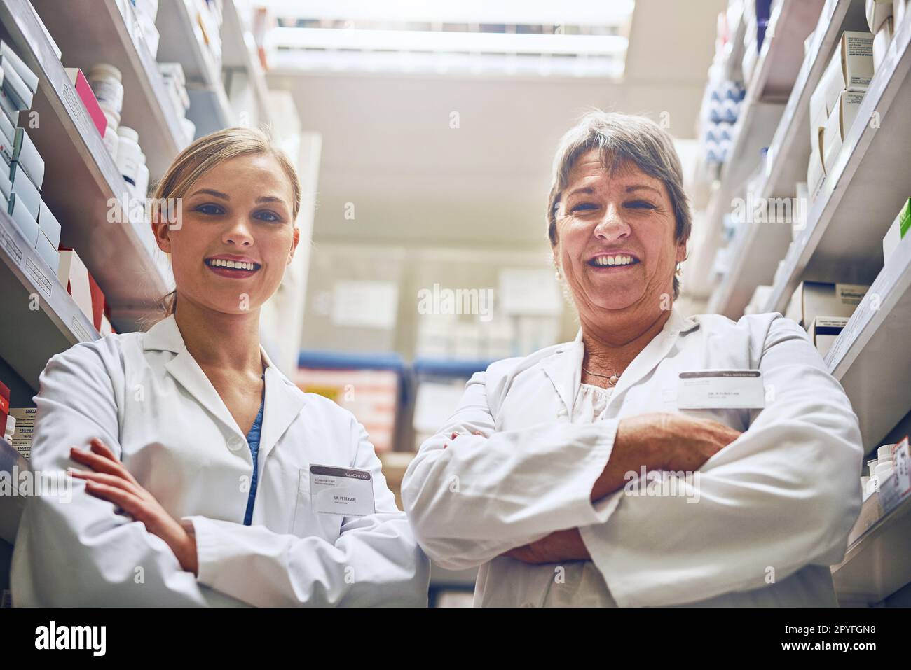 Nous jouons un rôle clé pour vous aider à récupérer. Portrait de pharmaciens debout dans une île avec leurs bras croisés. Banque D'Images