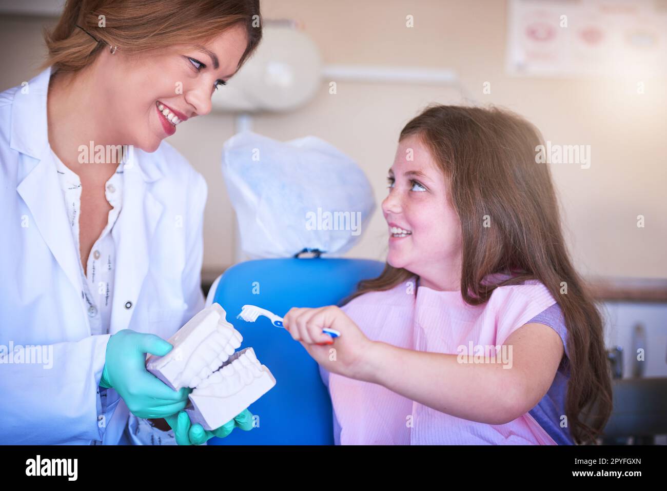 Prévenir la perte et la carie permanentes des dents. une femme dentiste enseignant à sa jeune patiente comment se brosser les dents. Banque D'Images