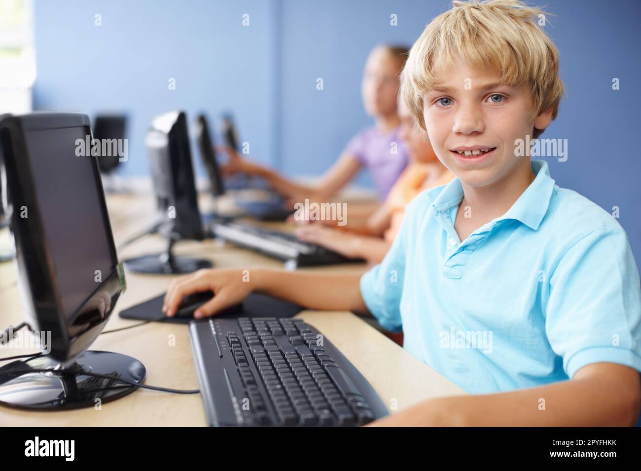 Travailler dur en classe informatique. Portrait d'un jeune garçon d'école mignon en classe informatique. Banque D'Images