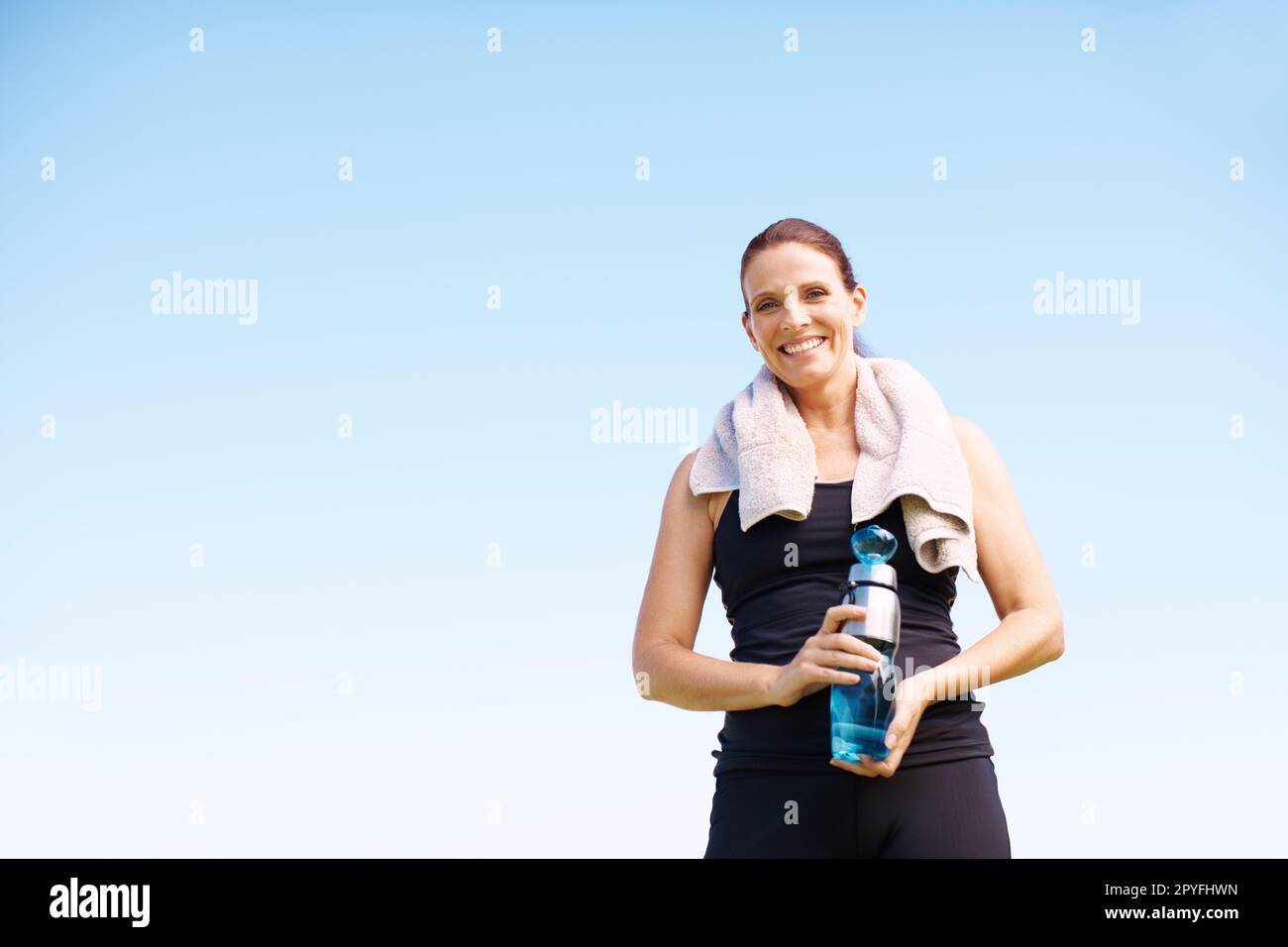 Shes plein d'énergie de la vie. Portrait d'une femme attrayante debout avec sa bouteille d'eau après un entraînement en plein air. Banque D'Images