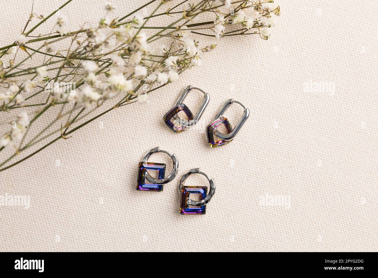 Ensemble de bijoux élégants de boucles d'oreilles argentées avec pierres précieuses. Ensemble de bijoux style minimaliste. Concept de bijouterie fait main. Banque D'Images