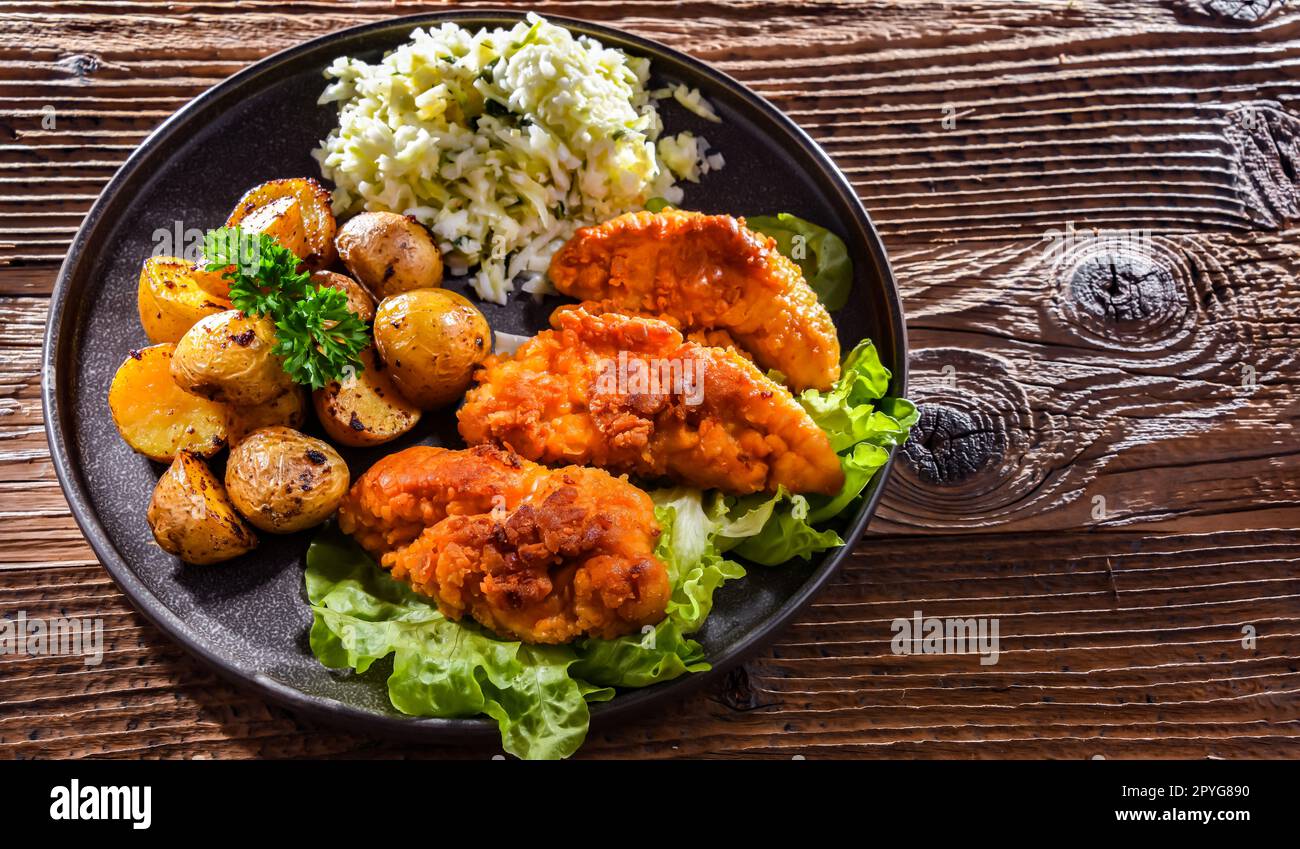 Côtelettes de poulet panées servies avec des pommes de terre et du chou Banque D'Images