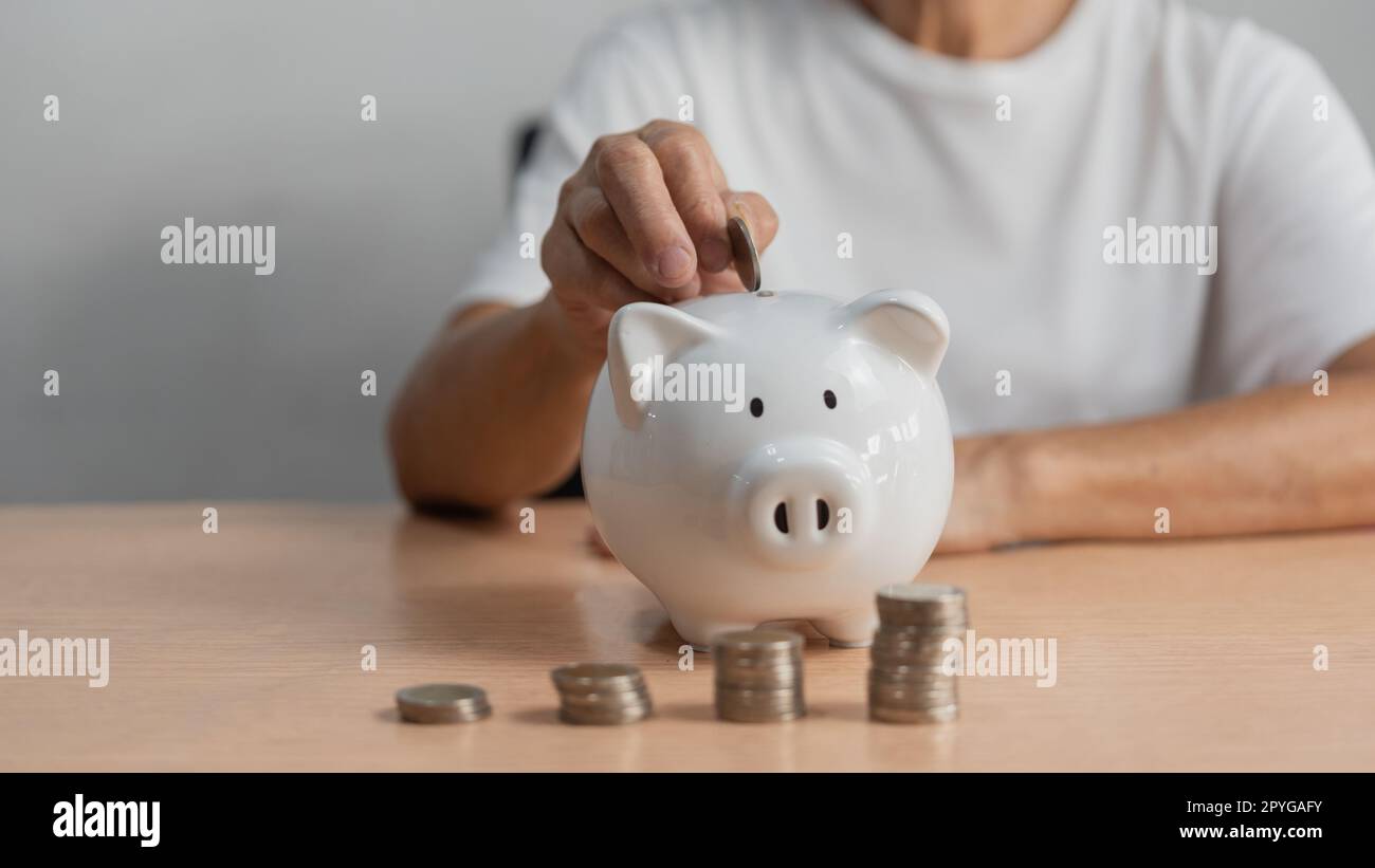femme mettant de la pièce dans la banque de piggy et économiser de l'argent pour le plan futur et le fonds de retraite gagnant de l'argent ou investissement ou de l'impôt pour les affaires concept. Banque D'Images
